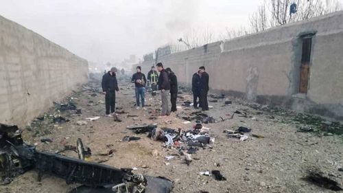 Iranian authorities look through the debris of the plane crash.