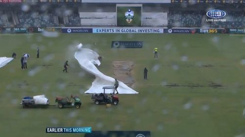 The groundsman was working to cover the pitch when a gust blew the covers clear. (9NEWS)