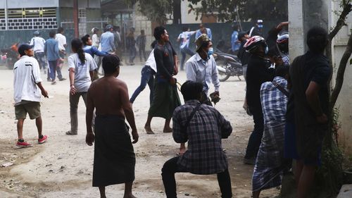 Anti-coup protesters react towards police, during a security operation in Mandalay, Myanmar, Saturday, Feb. 20, 2021.