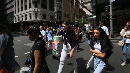 Pedestrians move across Market Street in Sydney, Australia. 