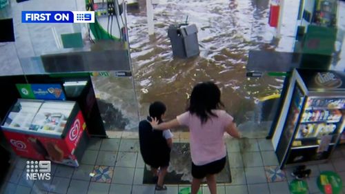 Owners of a BP service station in Mulgrave tried to save their equipment as waves lapped the business.