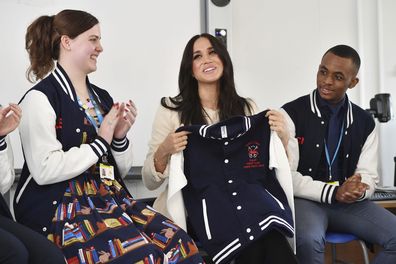 Meghan, the Duchess of Sussex is presented with a letterman jacket at the Robert Clack Upper School in Dagenham, Essex, March 6, 2020. 