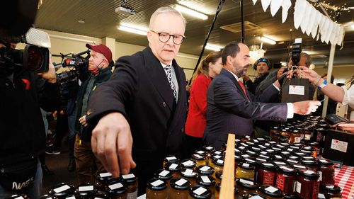 Anthony Albanese sorts jars of jam during the election campaign in Launceston.