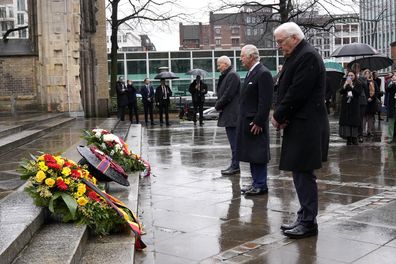 King Charles III, centre, and German President Frank-Walter Steinmeier, right, lay a wreath of flowers at St. Nikolai Memorial in Hamburg, Germany, Friday, March 31, 2023. 