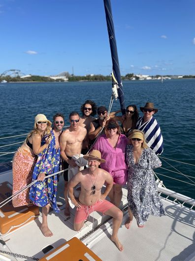 Shelly Horton Christmas party. Group gathered on boat, smiling for the camera, huddled together.