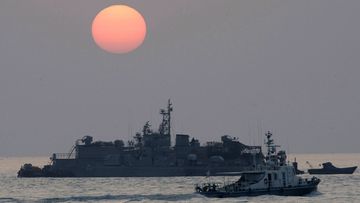A government ship sails past the South Korean Navy&#x27;s floating base as the sun rises near Yeonpyeong island, South Korea.
