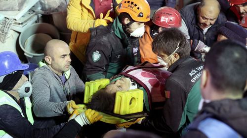 Rescuers carry an injured woman on a stretcher from the site of a collapsed building in Kartal district of Istanbul, Turkey.