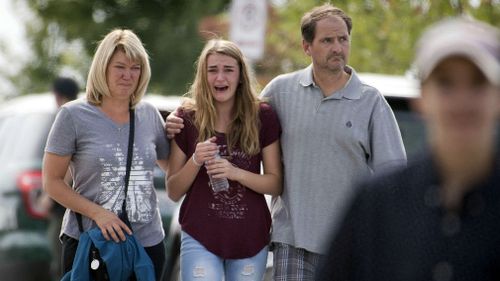 Parents reunited with their children, leave Freeman High School hours after a school shooting left one student dead and three injured in rural Rockford, Washington state. (AAP)