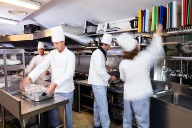 Team of chefs preparing food in the kitchen of a restaurant