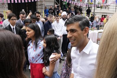 Prime Minister Rishi Sunak and his family, left, attend the Big Lunch party at Downing Street in London Sunday, May 7, 2023. 