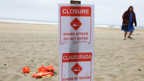 A sign informing visitors the beach is closed due to the shark attack.