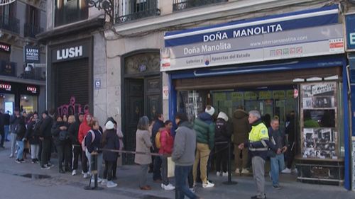 A queue of people waiting to buy tickets from the Dona Manolita lottery shop, in Madrid, Spain, Wednesday, Dec. 20, 2023 