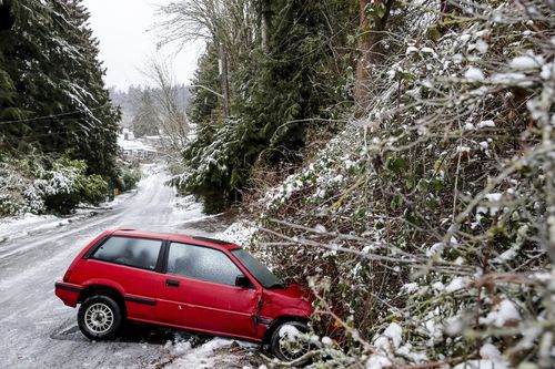 A car is left on the side of the road due to dangerous road conditions Friday, Dec. 23, 2022 in Seattle. 