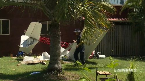 The ultralight aircraft stripped trees of their branches and knocked boards off a Pacific Haven home before crash-landing in the backyard. (9News)