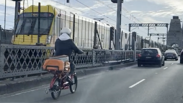 A food delivery cyclist has been filmed in peak-hour traffic on the Sydney Harbour Bridge.