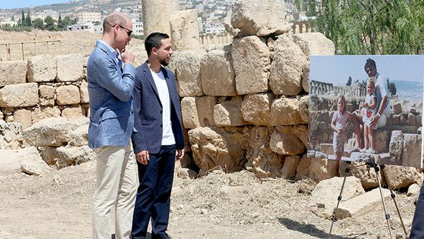 Prince William and Jordanian Crown Prince Hussein look at a photograph showing William's wife, the former Kate Middleton, her father Michael and younger sister Pippa in the ruins of the Roman city of Jerash in the 1980s. (AAP)