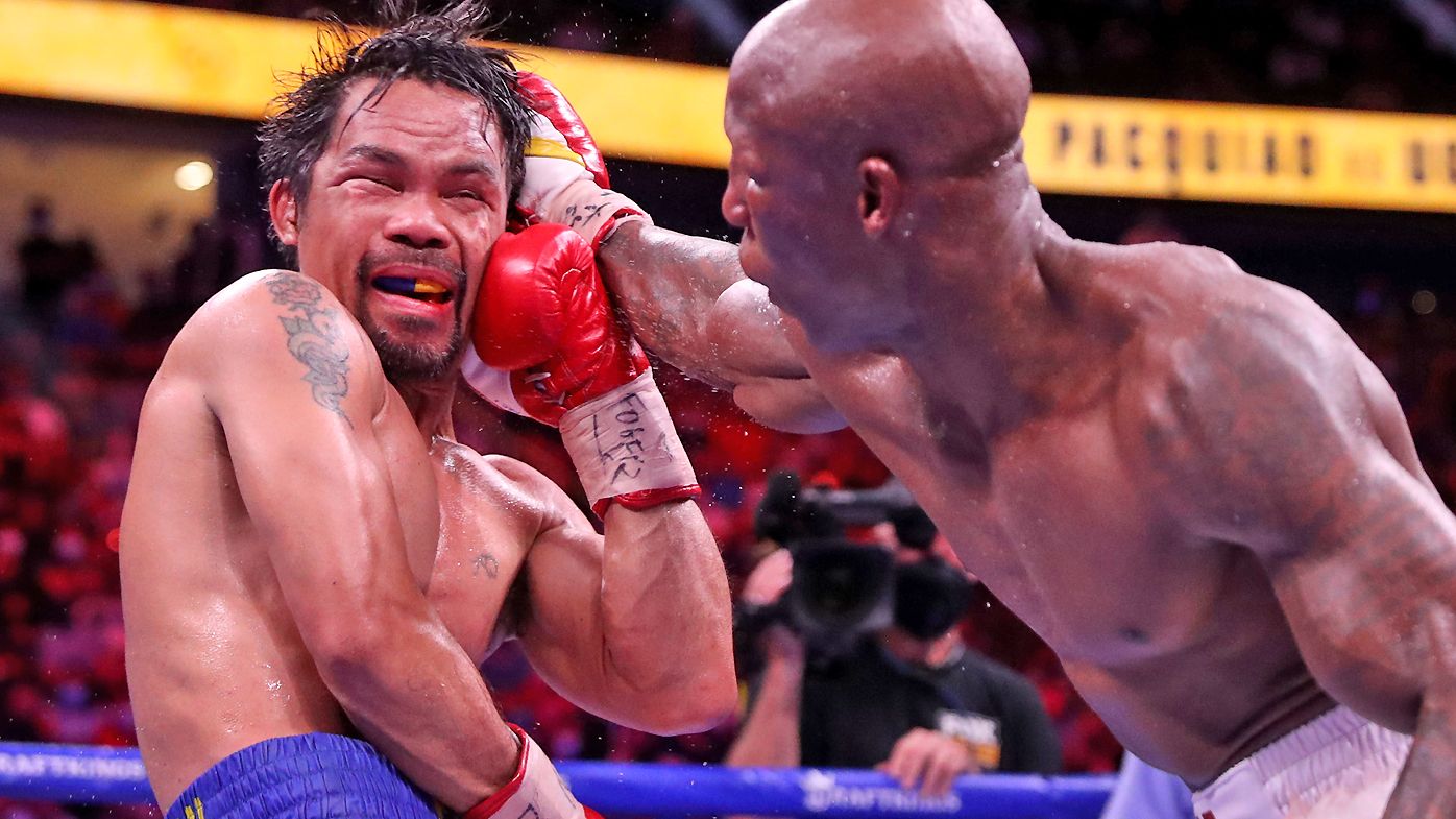 Manny Pacquiao (L) takes a punch from Yordenis Ugas during their WBA welterweight title fight at T-Mobile Arena