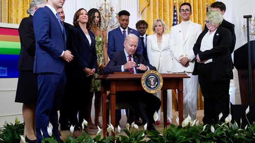 Le président Joe Biden signe un décret exécutif lors d'un événement pour célébrer le mois de la fierté dans la salle est de la Maison Blanche