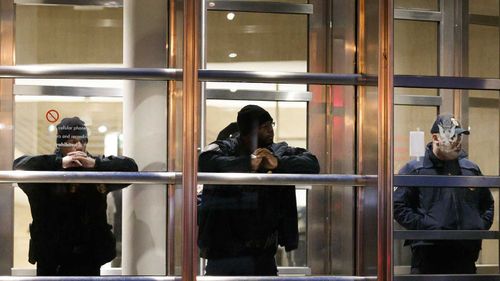 Police stand guard in the doorway of the courthouse where Joaquin 'El Chapo' Guzman is on trial.