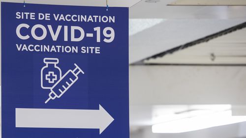 Signage at the Decarie Square Covid-19 vaccination site in Montreal, Quebec, Canada, on Wednesday, Jan. 12, 2022. Members of the armed services have been deployed in the province since January 3 to help with third dose vaccination efforts as hospitalizations rise. Photographer: Graham Hughes/Bloomberg