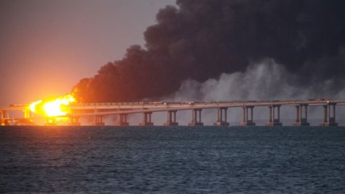 Flame and smoke rise fron Crimean Bridge connecting Russian mainland and Crimean peninsula over the Kerch Strait, in Kerch, Crimea, Saturday, Oct. 8, 2022. 