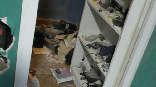 A man was allegedly found hiding behind this bookcase when police raided a house.