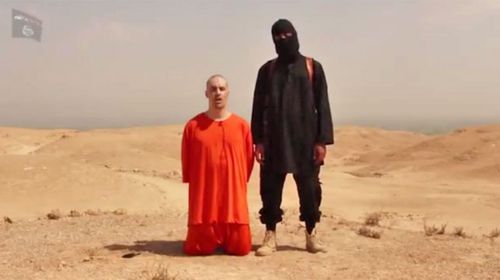 James Foley si inginocchia accanto a un combattente dello Stato Islamico nel video.