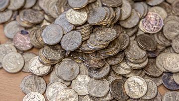 Two people have been charged over an alleged money laundering scheme involving damaged Australian coins.