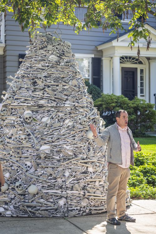 Yale epidemiology professor Gregg Gonsalves, spoke by a twelve-foot tall pile of artificial human bones at a vaccine equity demonstration. 