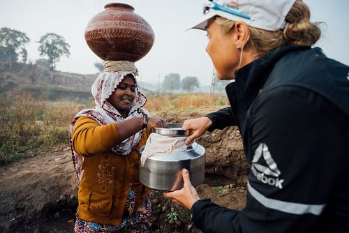 Mina Guli helps a local woman collect water near Dahod,India.