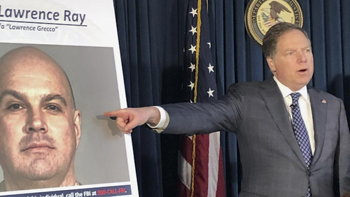 US Attorney Geoffrey Berman points to a photo of Lawrence Ray who is known for his role in a scandal involving former New York police commissioner Bernard Kerik. 