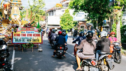 People riding motorbikes along the central street of Ubud in Bali. The island is introducing a $15 tourist tax. 