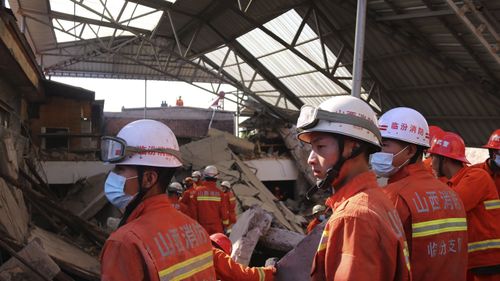 Rescue workers search for victims in the aftermath of the collapse.