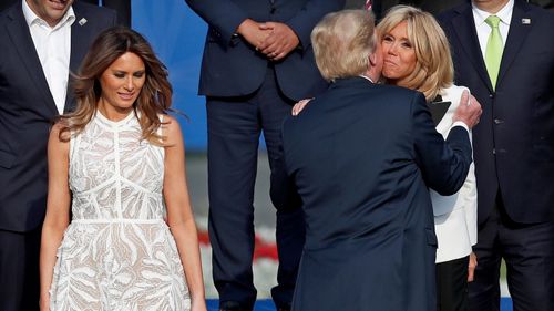 Mr Trump embraces Brigitte Macron, wife of French President Emmanuel Macron. (AAP)
