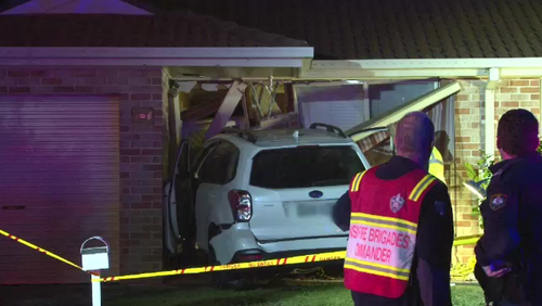 The car was left lodged in a house in Sydney's south-west.
