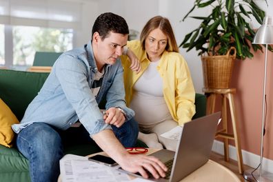 Pregnant woman and husband on laptop. 