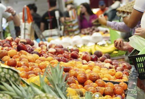 Foto geral de pessoas comprando frutas e vegetais no mercado da rainha Vic.