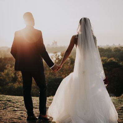 Bride and groom holding hands.