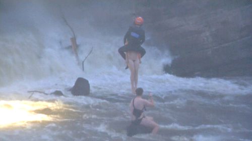 A man and woman who were swimming in the river got swept into the rapids and managed to climb onto a rock