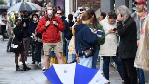 People are seen queuing outside a Centrelink office in Bondi Junction