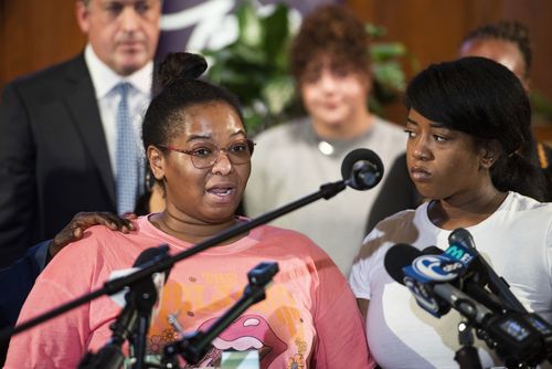 Josephine Wamah, left, with Jasmine Wamah, right, sisters of shooting victim Joseph Wamah Jr., speaks at a news conference with members of the District Attorney's office, elected officials, and community partners at Salt and Light Church in Philadelphia.