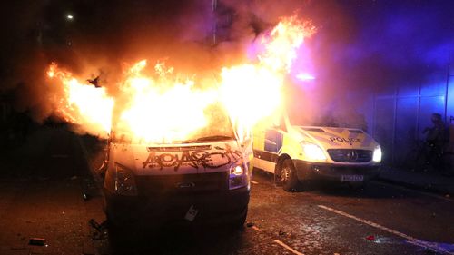 A vandalised police van on fire outside Bridewell Police Station,  as people took part in a protest demonstrating against the Police and Crime Bill.