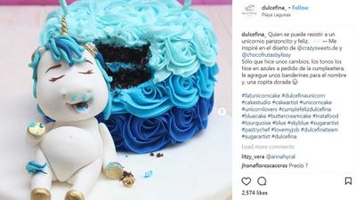 Pudgy unicorn rests on baby blue unicorn cake