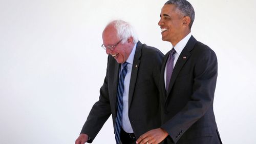 Senator Bernie Sanders walks with Barack Obama