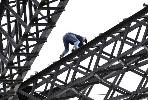 Cook perched dangerously on the beams during the morning peak, forcing police to close all lanes in both directions. Picture: AAP