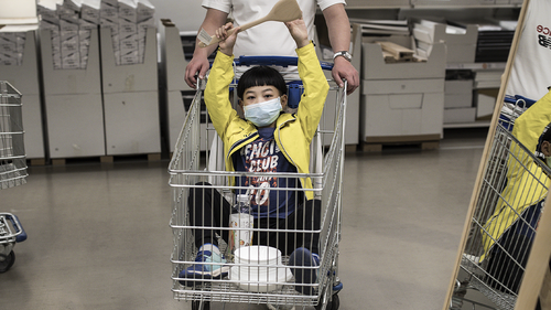 A boy wears a protective mask while sitting in a cart at an IKEA on April 25, 2020 in Wuhan, China. 