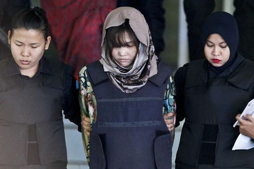 Vietnamese Doan Thi Huong, center, is escorted by police as she leaves after a court hearing at Shah Alam High Court in Shah Alam, Malaysia