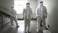 Health officials wearing protective gear prepare to spray disinfectant to help reduce the spread the new coronavirus ahead of school reopening in a cafeteria at a high school in Seoul, South Korea
