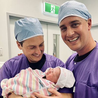 Australian couple Alex Needs and Raymond Palmer with their baby