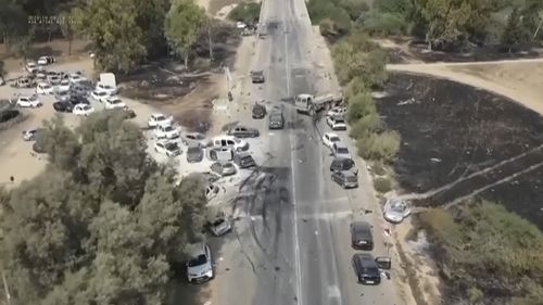 This image from video provided by South First Responders shows charred and damaged cars along a desert road after an attack by Hamas militants at the Tribe of Nova Trance music festival near Kibbutz Re'im in southern Israel.